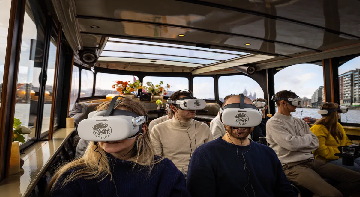 Real visitors wearing VRVoyage headsets aboard the boat in Amsterdam